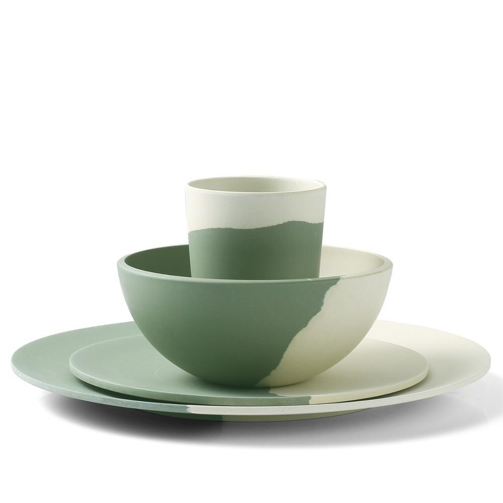 a green cup sitting on top of a plate