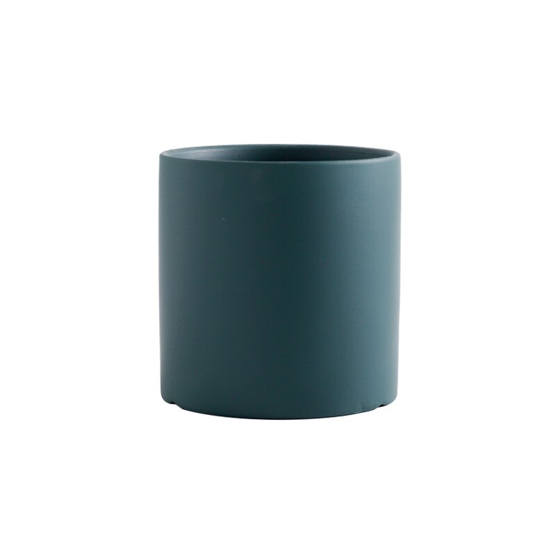 a green vase is sitting on a table