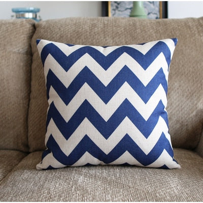 a blue and white striped cat sitting on a couch