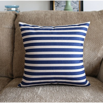 a blue and white striped cat sitting on a couch