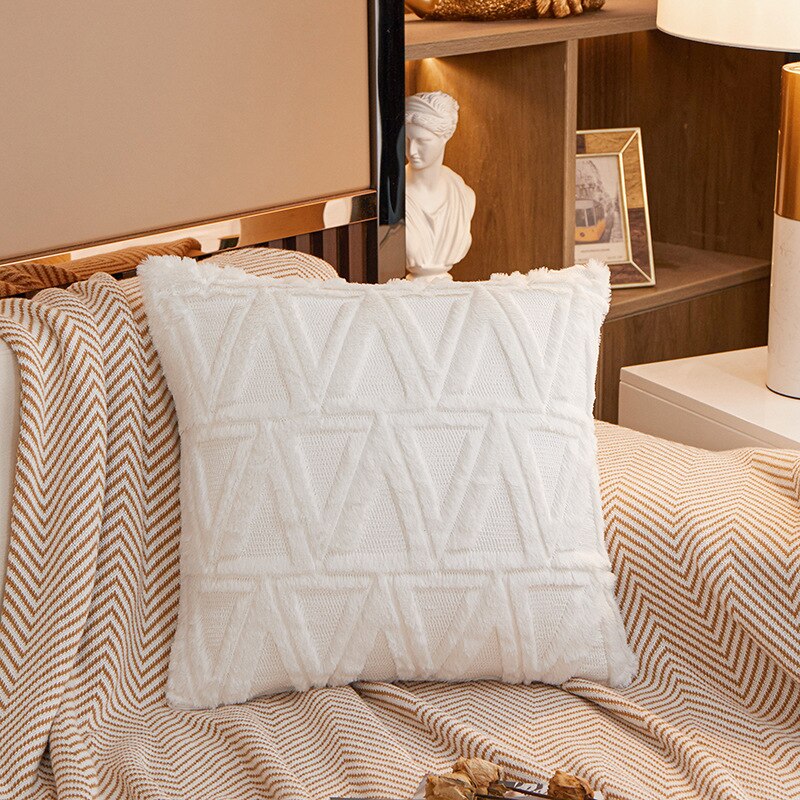 a bed with a white comforter and pillows