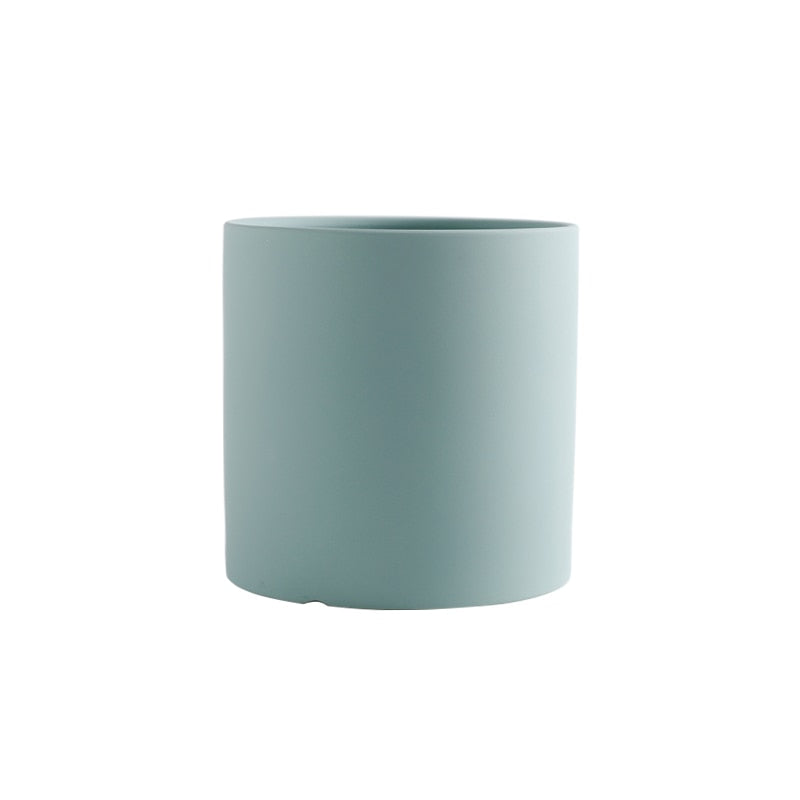 a green vase is sitting on a table