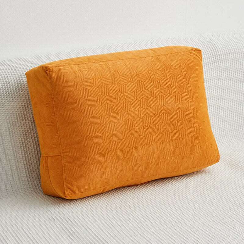 a large orange pillow sitting on a white surface 