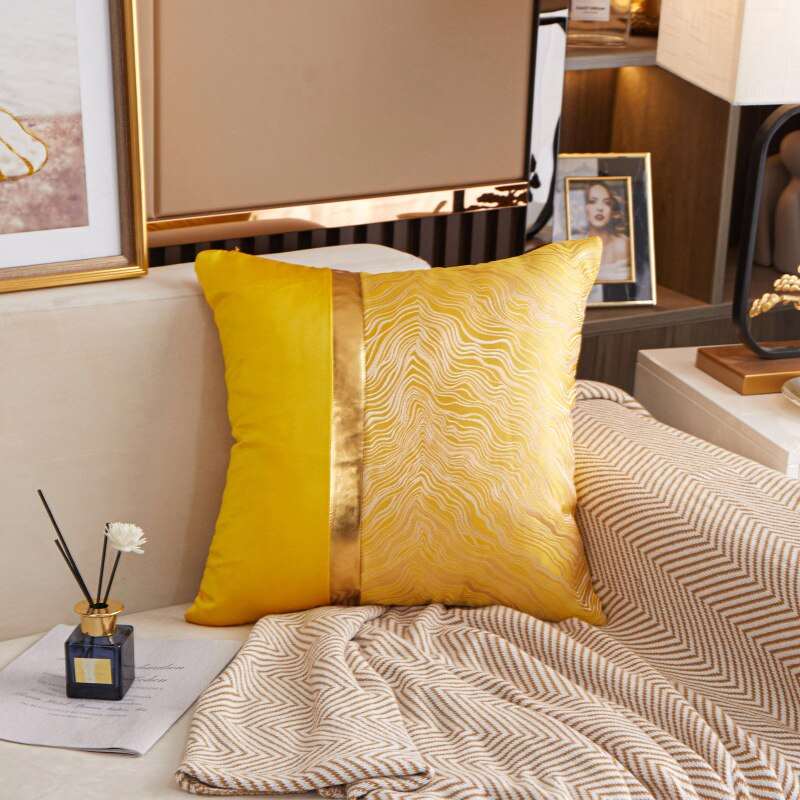 a bed with a yellow blanket and pillows 