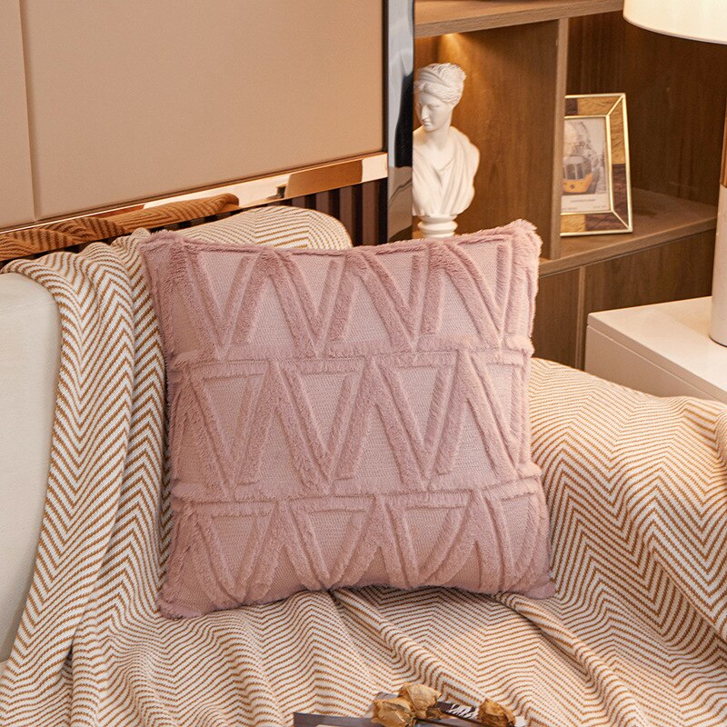 a bed with a pink comforter and pillows 