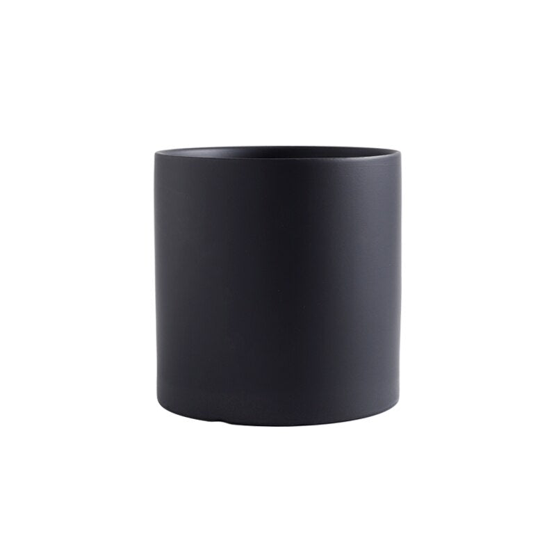 a black coffee cup sitting on a table 